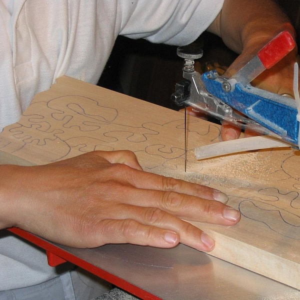 Découpe artisanale d'un puzzle en bois de hêtre.